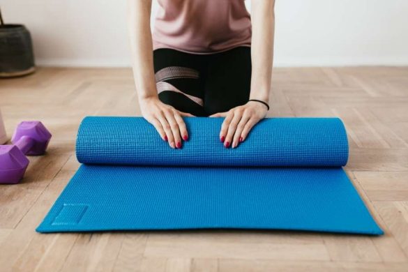 emme préparant son tapis de yoga bleu pour reprendre le sport à domicile