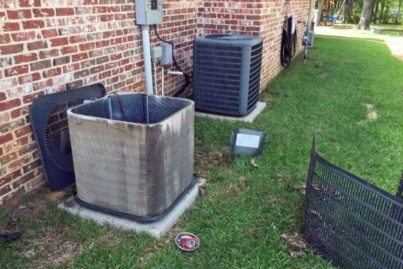 Une unité de climatisation extérieure partiellement démontée pour la maintenance de son évacuateur de condensats.