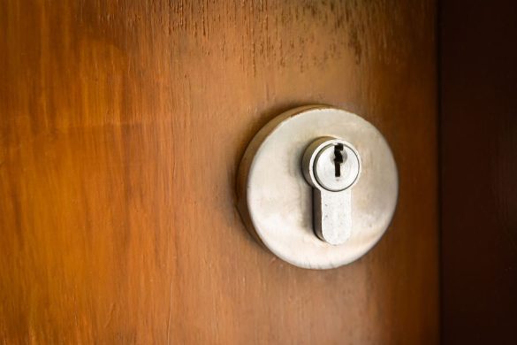 Un cylindre de serrure encastré dans une porte en bois, idéal pour évaluer et choisir le meilleur protège-cylindre.